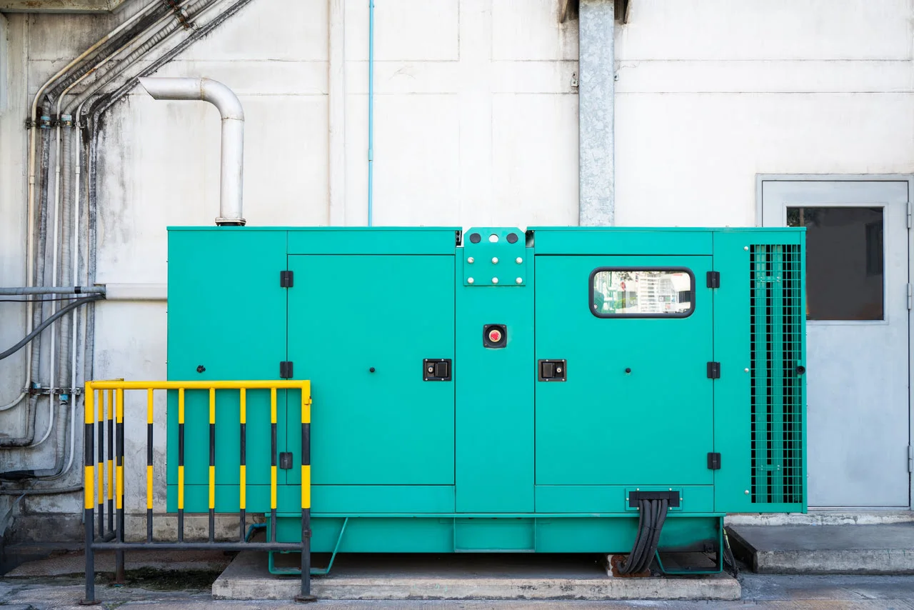 A green generator sitting next to a wall.