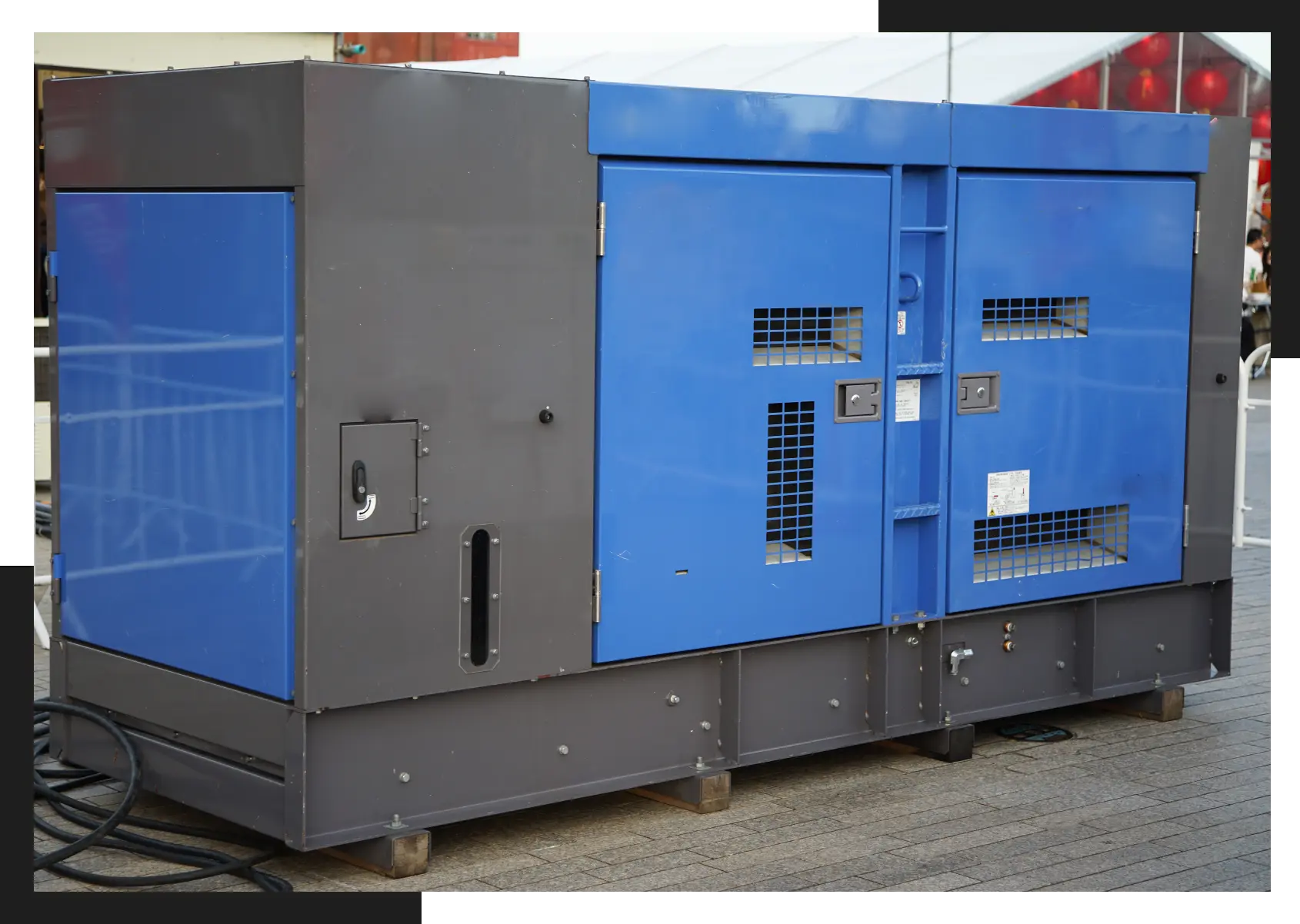 A blue and gray generator sitting on top of concrete.